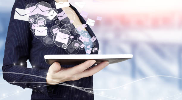istock Sending email.Bulk mail. Hand hold white tablet with digital hologram Email and sms sign on light blurred background. Email and sms marketing concept. 1351347657