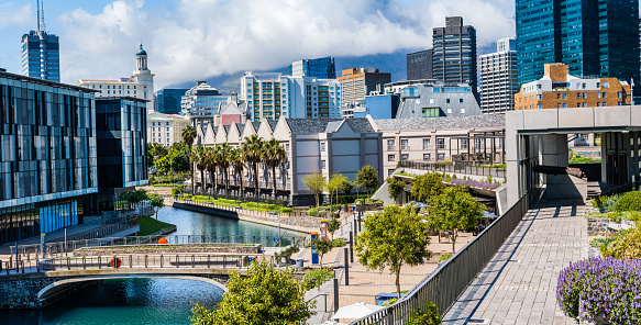 Panorama shot of Cape Town city overlooking the canal and clouds covering table mountain