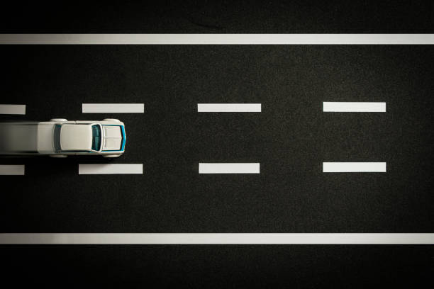 istock Top view of tiny model car speeding on black highway. 1351350423