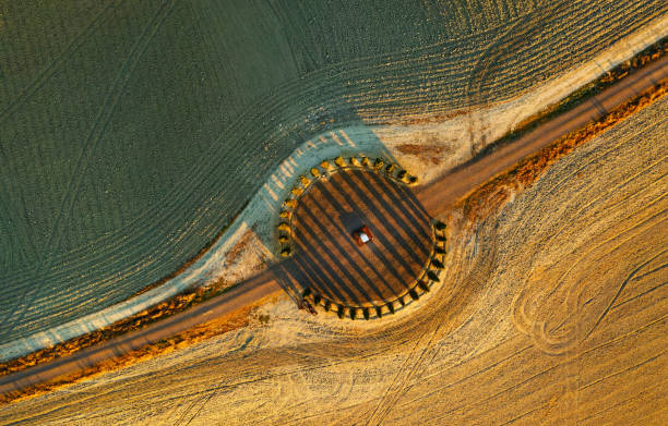 vista aérea de las hermosas colinas de la val d'orcia en la toscana con la arboleda en forma de círculo de ciprés cerca de montalcino, italia, colinas cultivadas con trigo, columna jónica de helidon xhixha, reflejos en el medio - val dorcia fotografías e imágenes de stock