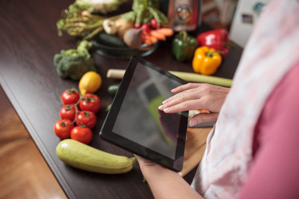 istock High angle view of an unrecognizable woman using tablet while preparing vegetarian meal 1351358140