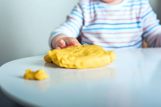 놀이방 클로즈업 및 복사 공간에서 노란색 플라스틱 플레이 도를 재생 유아 소년.. - playdoh 뉴스 사진 이미지