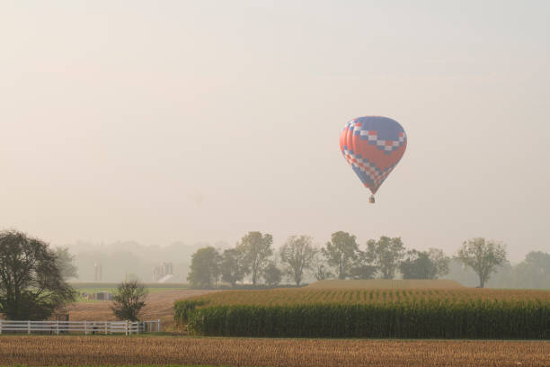 istock Hot air balloon flying over farmland 1351358594