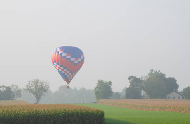 Hot air balloon flying over farmland