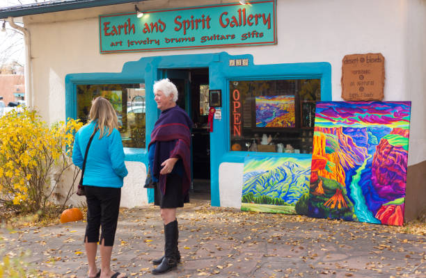 Taos, NM: Two women chatting outside a colorful art gallery in downtown Taos.