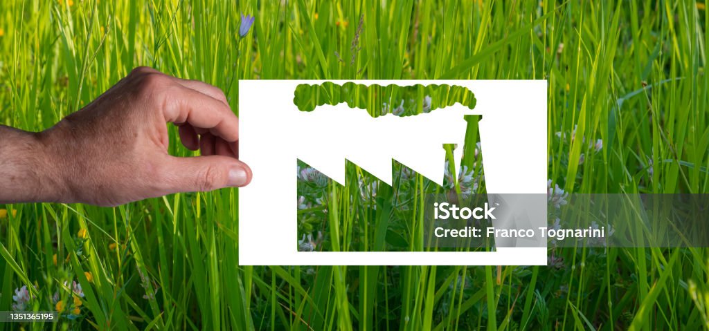 Green wash: A man's hand holds a blank sheet of paper with the silhouette of a factory cut out Green wash: A man's hand holds a blank sheet of paper with the silhouette of a factory cut out. Green grass background.
Not everything "green" is ecological Greenwashing Stock Photo