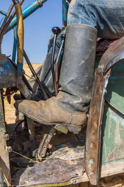 istock Boot on the controls of a farm tractor during harvest. 1351366278