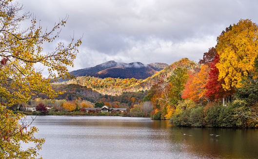 Lake Junaluska in autumn colors. Lake in colorful autumn mountainsHotels buildings and houses by autumn lake in colorful forest. Blue Ridge Mountains. Near Asheville, North Carolina, USA.