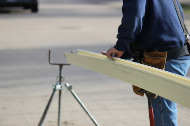 istock Male contractor preparing seamless gutter to be installed on a residential building 1351370249