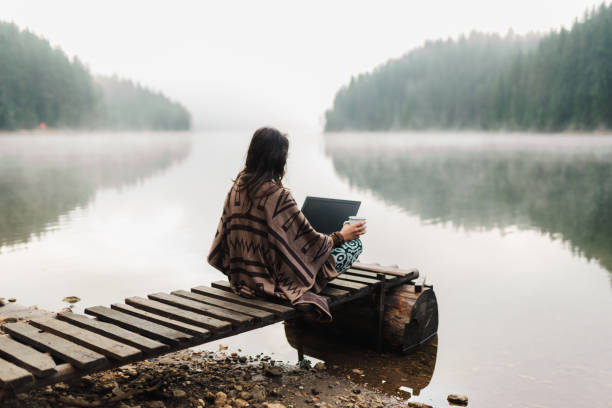 istock Woman Relaxing In Nature And Using Technology 1351372034