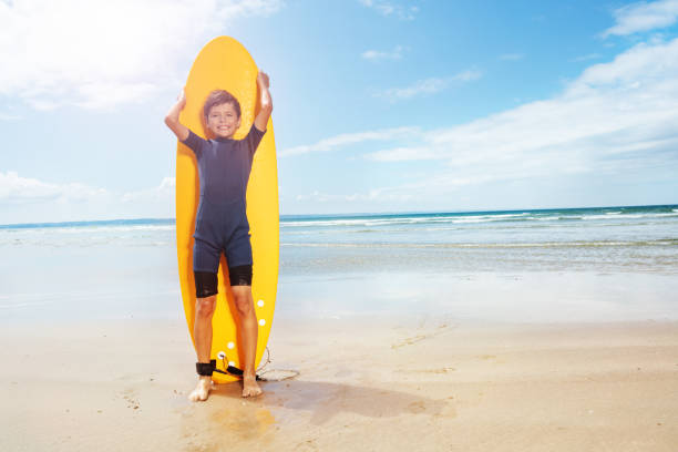 Handsome young man with surfboard on a beach