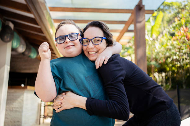Portrait of mother and son with down syndrome in  backyard. stock photo
