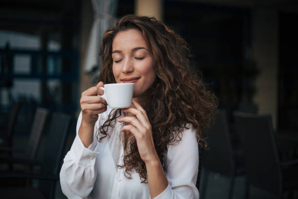 kobieta delektowająca się cappuccino w kawiarni - tasting zdjęcia i obrazy z banku zdjęć