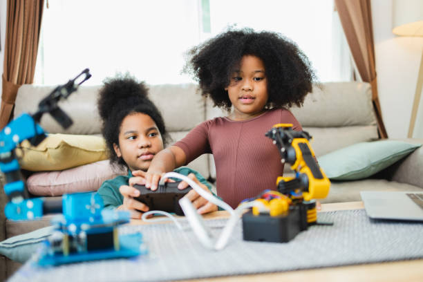 istock Two African American girls learned robot arms with a program computer. Innovative technology mechanical for Assistive Technology 1351380336