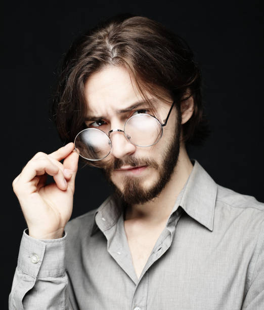 istock Young man wearing eyeglasses over black background. Lifestyle co 1351387964