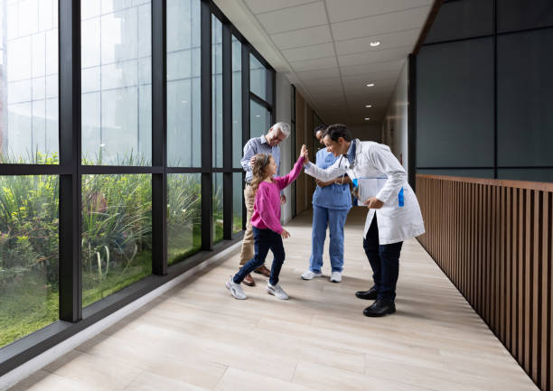 doctor giving a high-five to a girl at the hospital - doctor patient greeting talking imagens e fotografias de stock