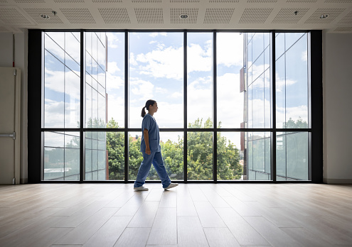 Latin American female nurse walking in the corridor while working at the hospital - healthcare and medicine