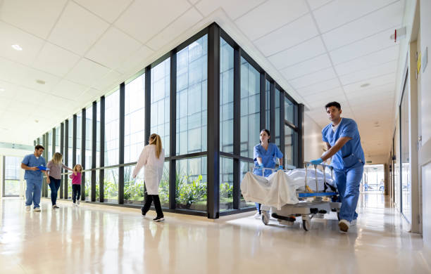 medici che assistono i pazienti in ospedale - indoors inside of built structure contemporary foto e immagini stock