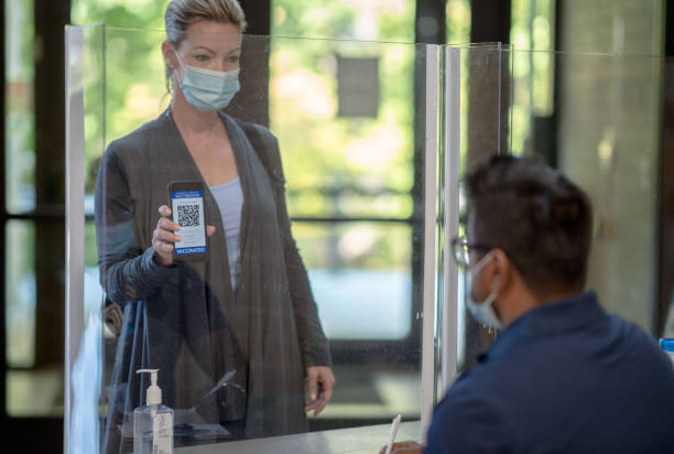 une femme montrant son passeport vaccinal - plexi glass science technology healthcare and medicine photos et images de collection