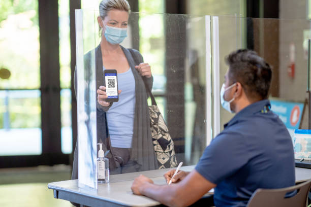 une femme montrant son passeport vaccinal - plexi glass science technology healthcare and medicine photos et images de collection