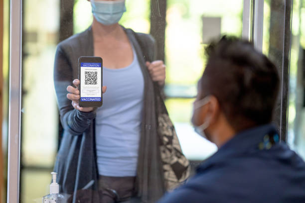 une femme montrant son passeport vaccinal - plexi glass science technology healthcare and medicine photos et images de collection