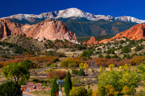 Garden of the Gods Park in Autumn 2011 with Pikes Peak, located near Colorado Springs. Notice the tiny tourists taking a picture at the stone sign.