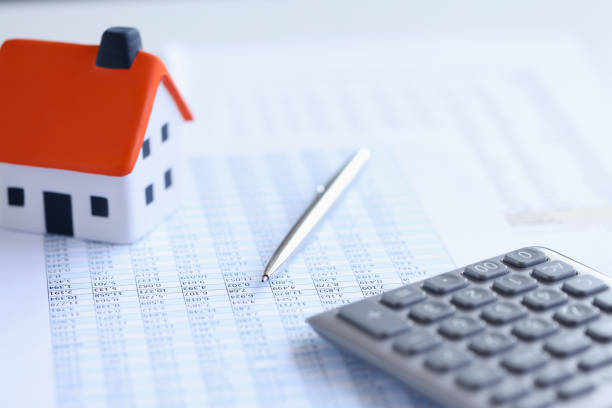 istock Calculator with small house and loan documents on table closeup 1351405770