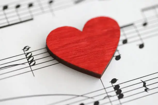 Small red wooden heart with musical notes. Love to study music concept