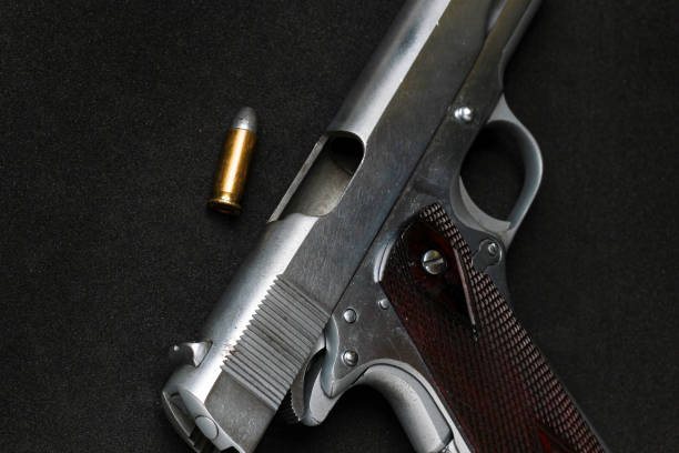 istock Automatic white gun stainless steel pistol weapon with real bullet ammo head in black background 1351408749