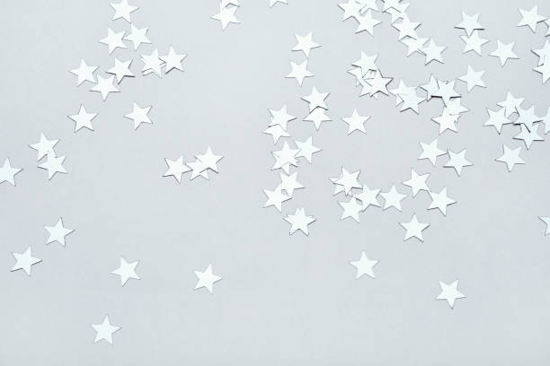 istock Silver stars confetti on gray background. Christmas or winter festive background 1351412721