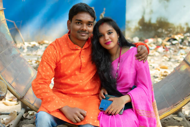 felicemente sposata coppia in abiti etnici tradizionali seduti in un parco. - wife foto e immagini stock
