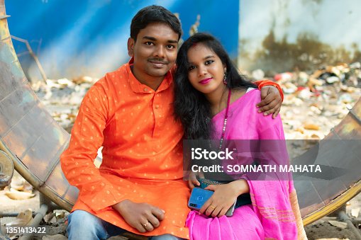 istock Happily married couple in traditional ethnic clothes sitting in a park. 1351413422
