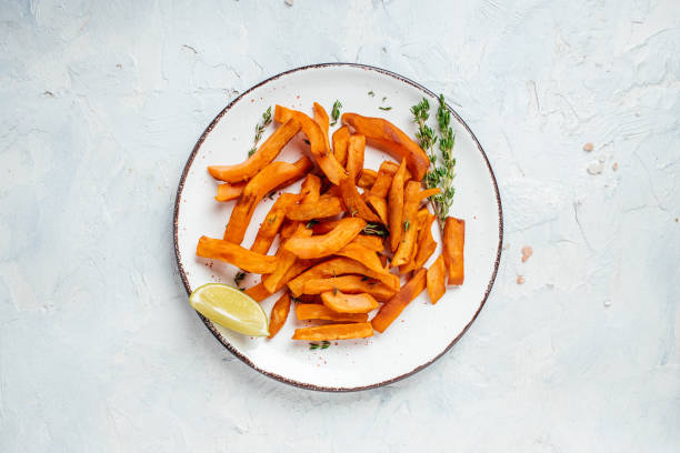 batata frita assada com limão e ervas no prato. vista superior - sweet potato french fries yam baked - fotografias e filmes do acervo