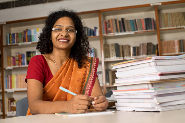 istock Portrait of teacher sitting at school library 1351415899