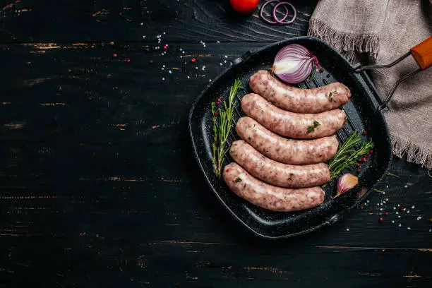 Raw stuffed sausages on srill pan, Sausages in cookware. Sausages for grilling. banner, menu, recipe place for text, top view.