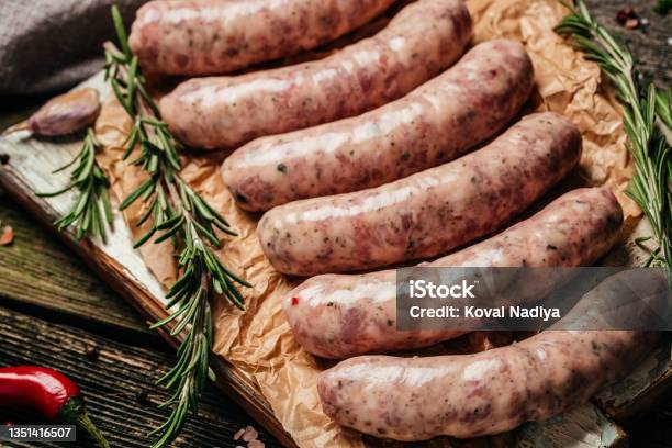 Raw Sausages With Rosemary On A Wooden Background Sausages For Grilling Food Recipe Background Close Up Stock Photo - Download Image Now