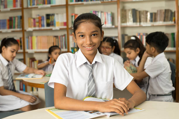 istock School children studying book at library 1351417058
