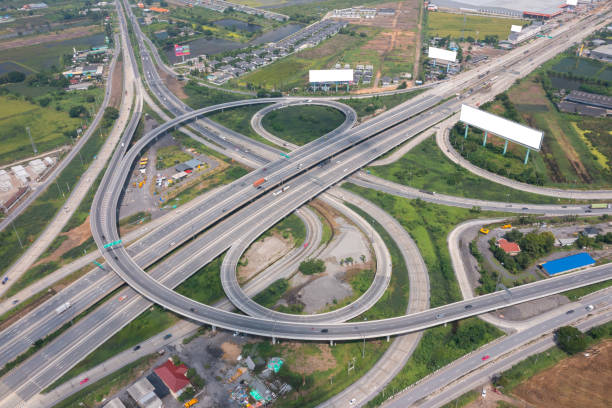 istock Aerial view of highway junctions with roundabout. Bridge roads shape circle in structure of architecture and transportation concept. Top view. Urban city, Bangkok at sunset, Thailand. 1351417189