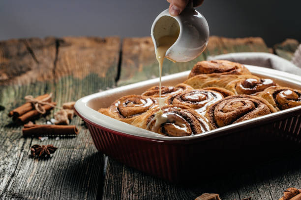 istock Cinnamon sinnabon bun, with vanilla creame on wooden background. top view 1351417251
