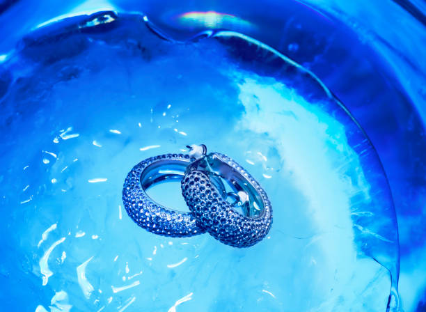 istock Earrings with rhinestones on a blue ice background 1351417393