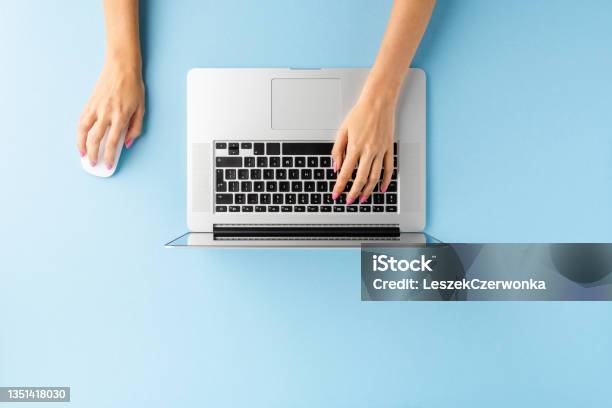 Overhead Shot Of Female Hands Using Laptop On Blue Office Desktop Business Background Flat Lay Stock Photo - Download Image Now