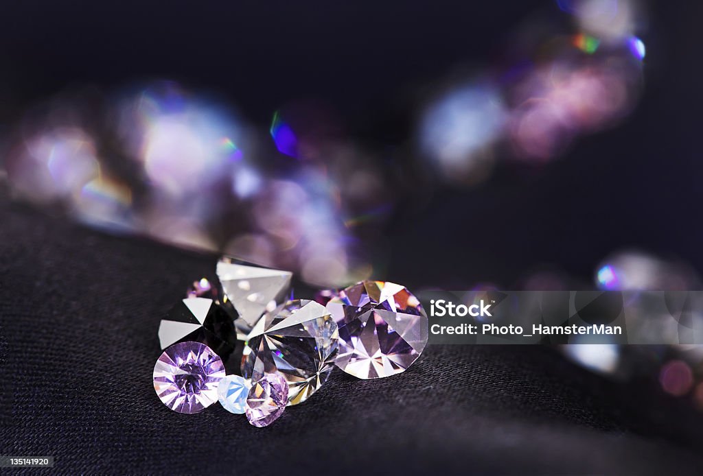 Diamond (small purple jewel) stones heap over black silk cloth Diamond (small purple jewel) stones heap over black silk cloth background Diamond - Gemstone Stock Photo