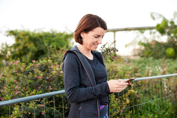 istock A middle-aged woman looking at a smartphone app after running. 1351421526