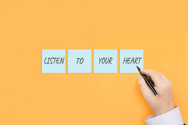 Motivational quote Listen to your heart. Handwritten inscription on sticky notes.