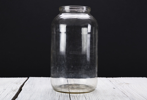 Glass bottles and jars of different shapes and sizes on white background