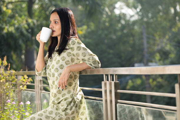 istock Woman having coffee while admiring view from balcony 1351426627