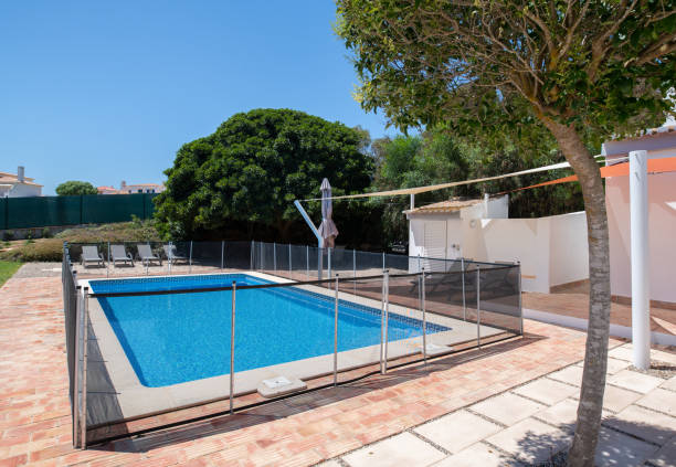 istock Fenced swimming pool with brick tiled surround 1351430645