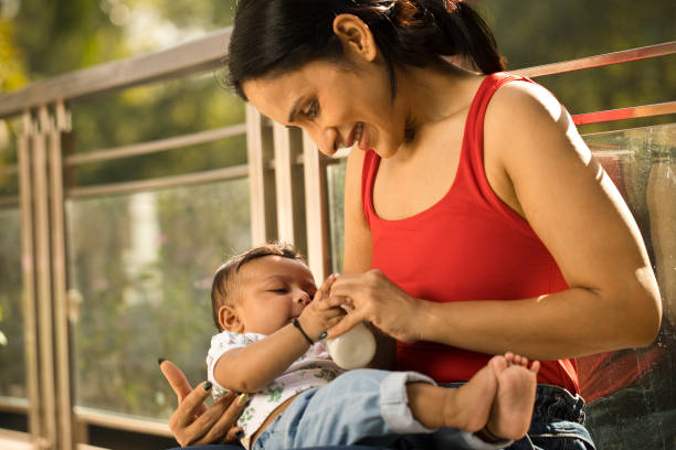 istock Young mother feeding her son from milk bottle 1351430818