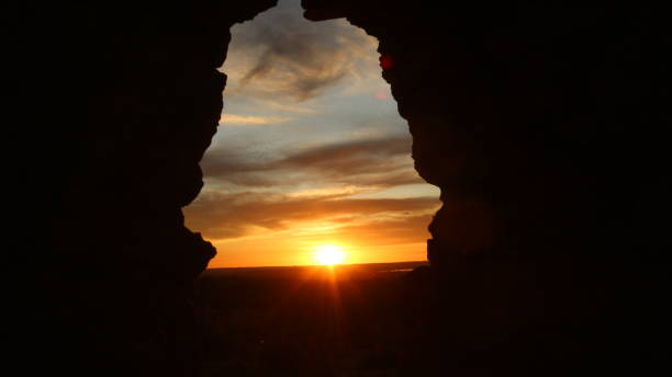 istock A hole in a mud wall overlooking the sunset 1351431253