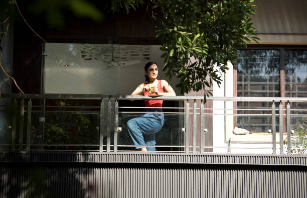 Woman having coffee while admiring view from balcony